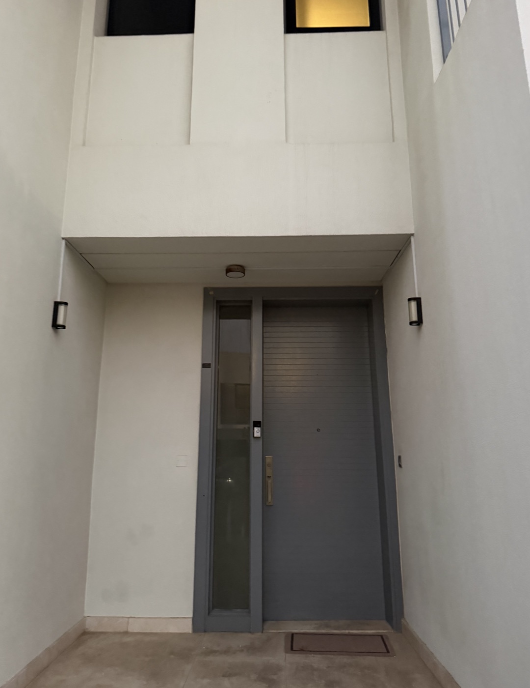 Front entrance of Villa 217, with a grey entrance door and white exterior walls
